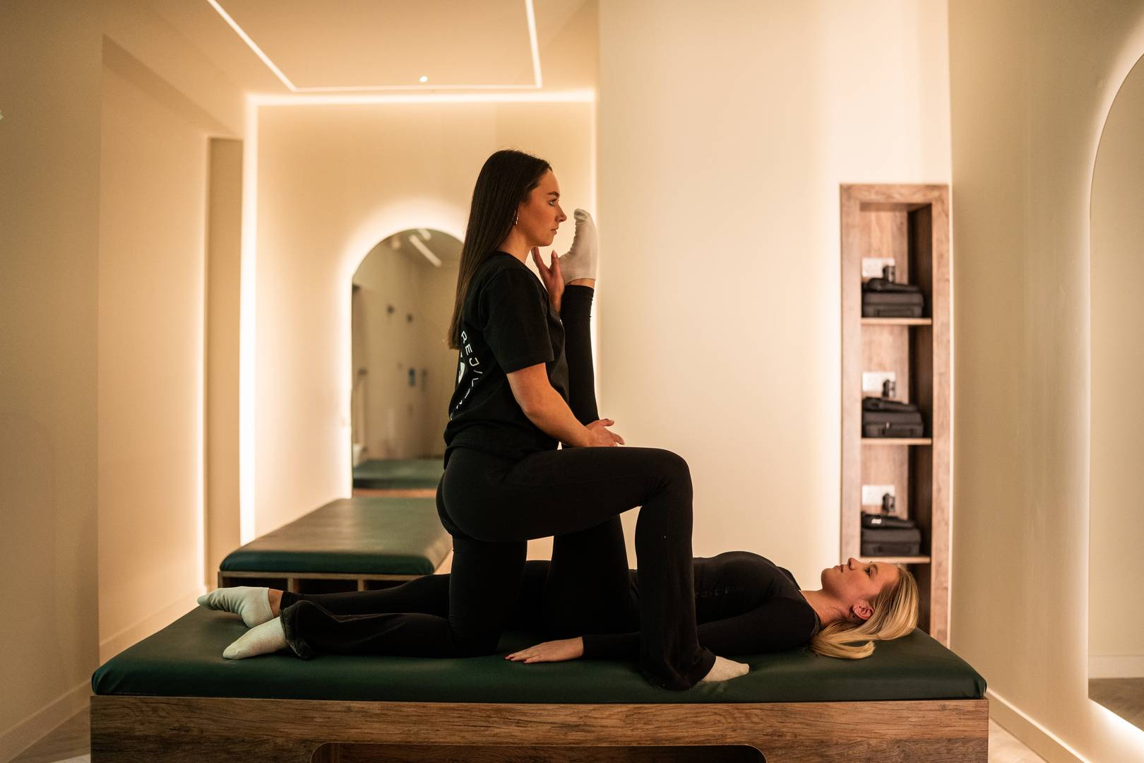 Personal trainer helping person stretch