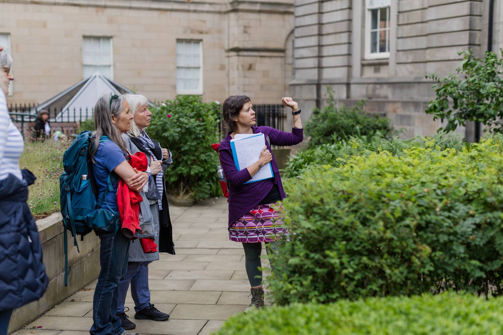 Guide standing in the Archivists' Garden in front of a Rowan tree in Edinburgh,© Women in Travel CIC