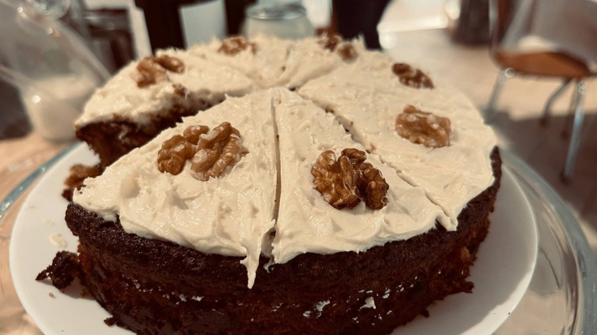 A coffee walnut cake covered with frosting and walnuts.,© Earth in Common