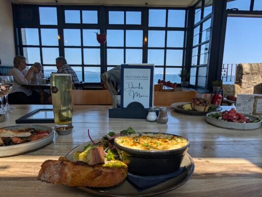 Interior of the Old Chain Pier with group dining and food on a table
