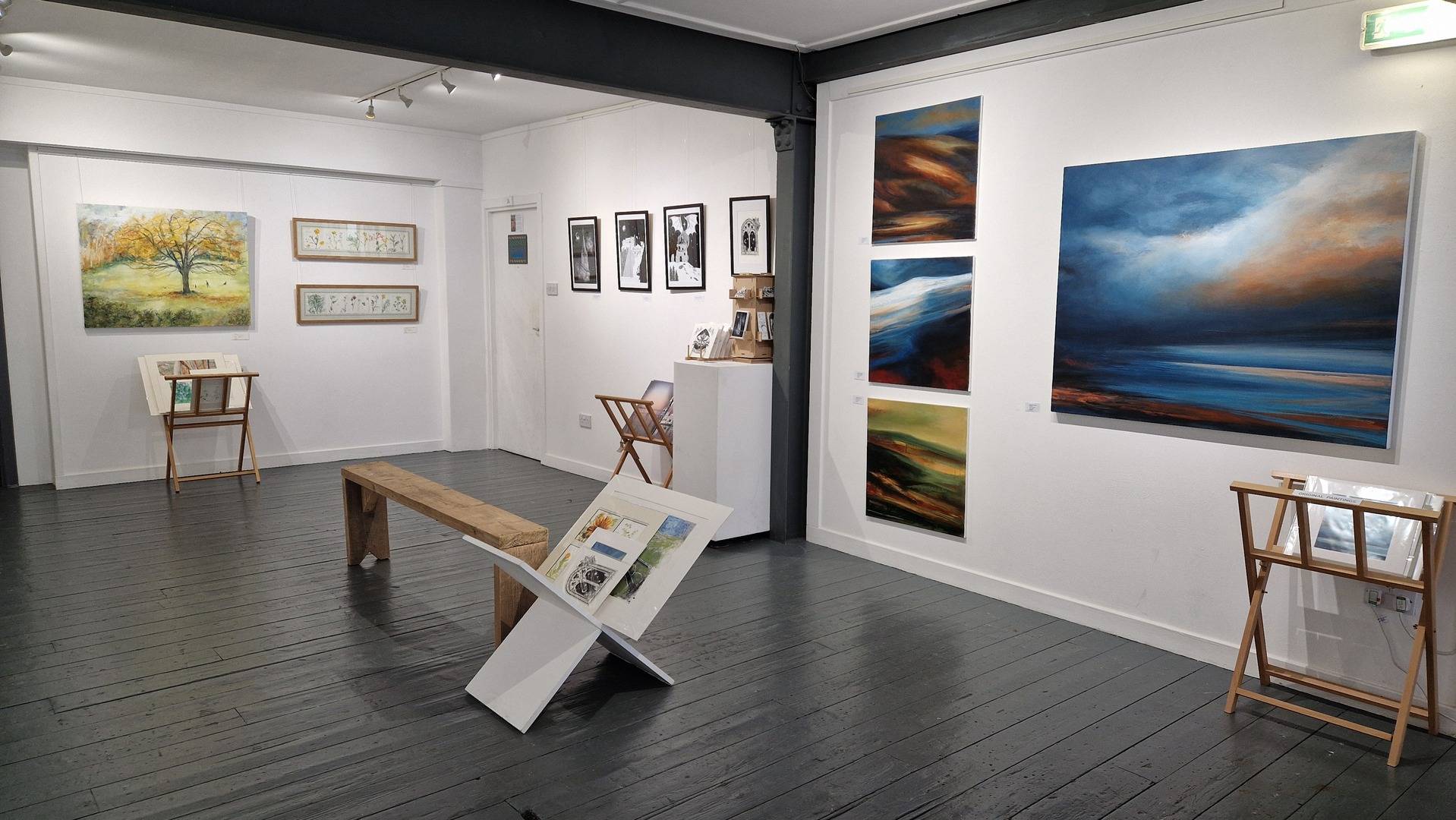 Paintings and prints displayed in gallery space.