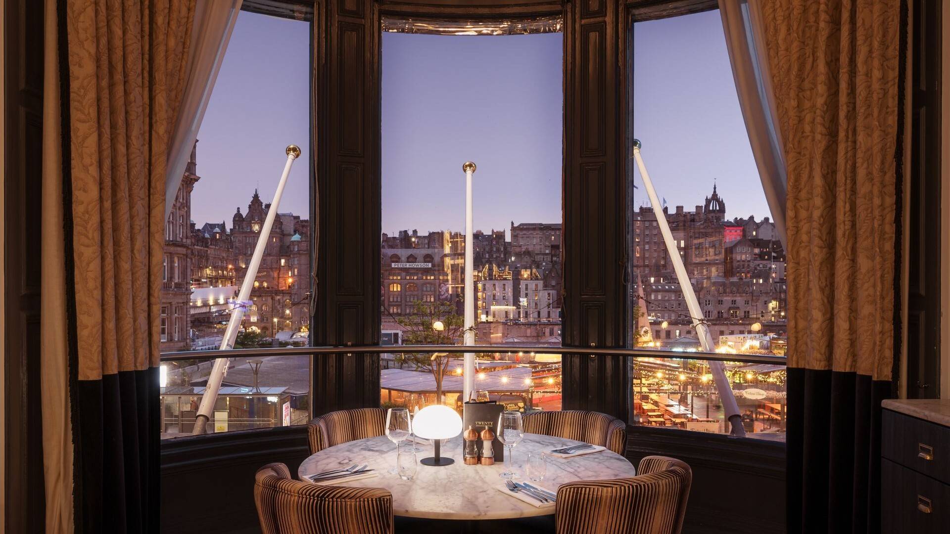 A table for four in a bay window at Twenty, looking out over Edinburgh’s Old Town at dusk.