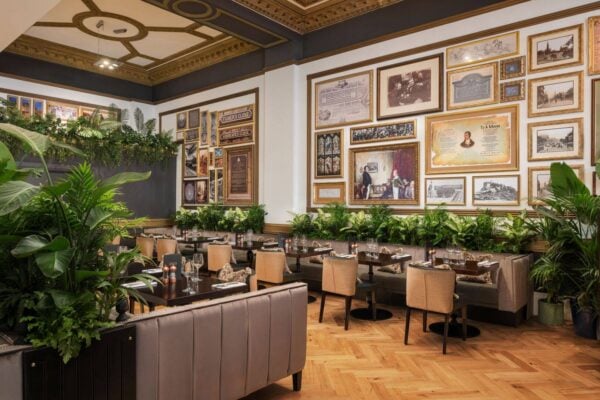 Row of tables with wall behind covered in framed pictures