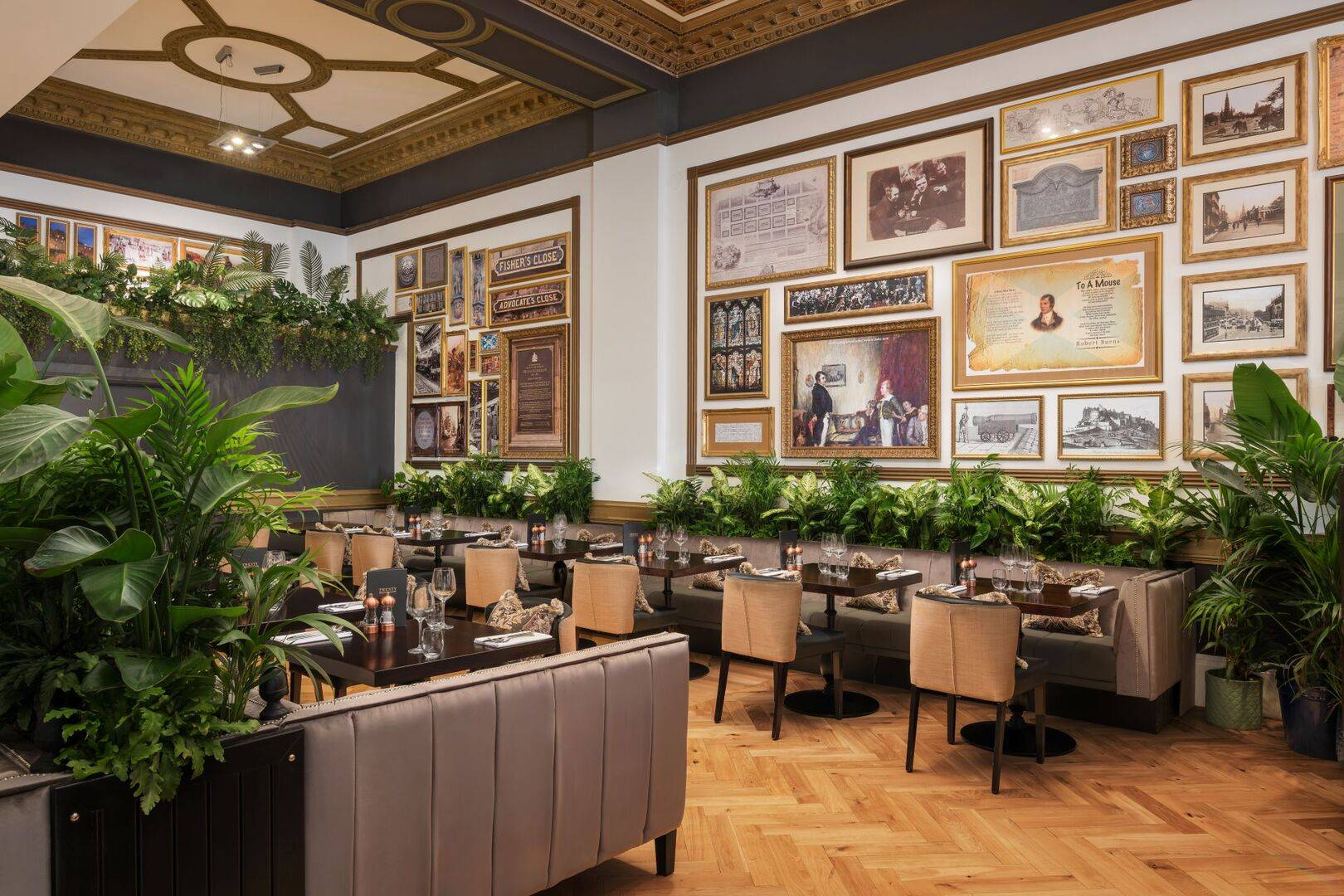 Row of tables with wall behind covered in framed pictures