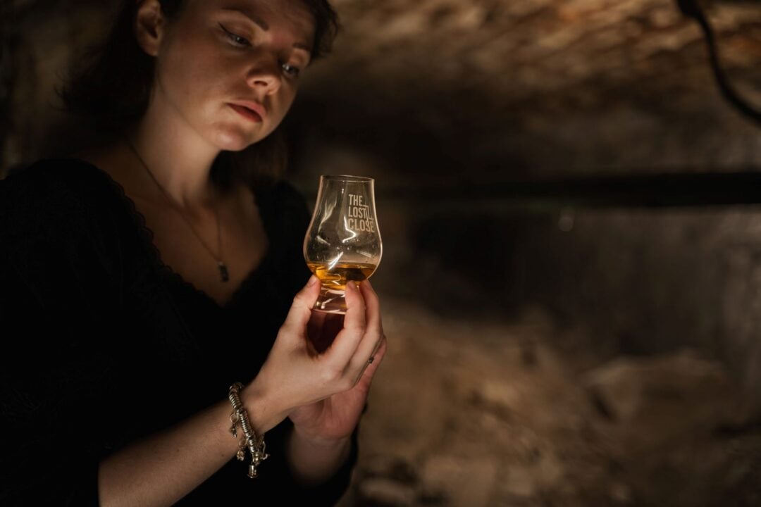 Close-up of a woman holding a glass of whisky.