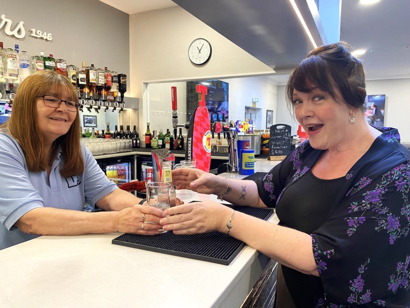 A woman getting served a drink at a bar.